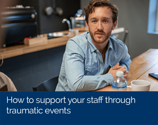 Supporting staff through traumatic events image of man with elbows on table looking concerned